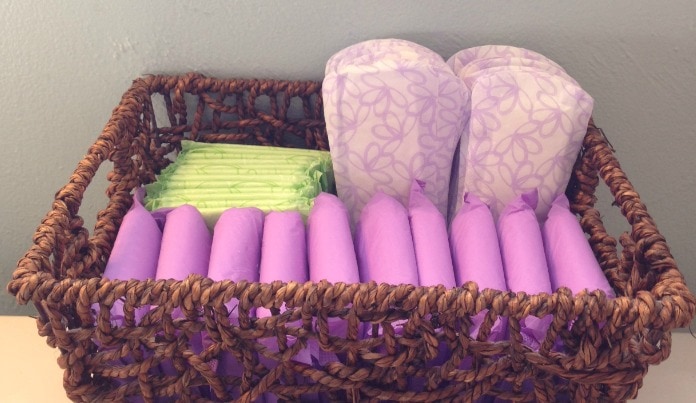 basket filled with three types of postpartum pads - purple overnight pads, thin pads, and panty liners